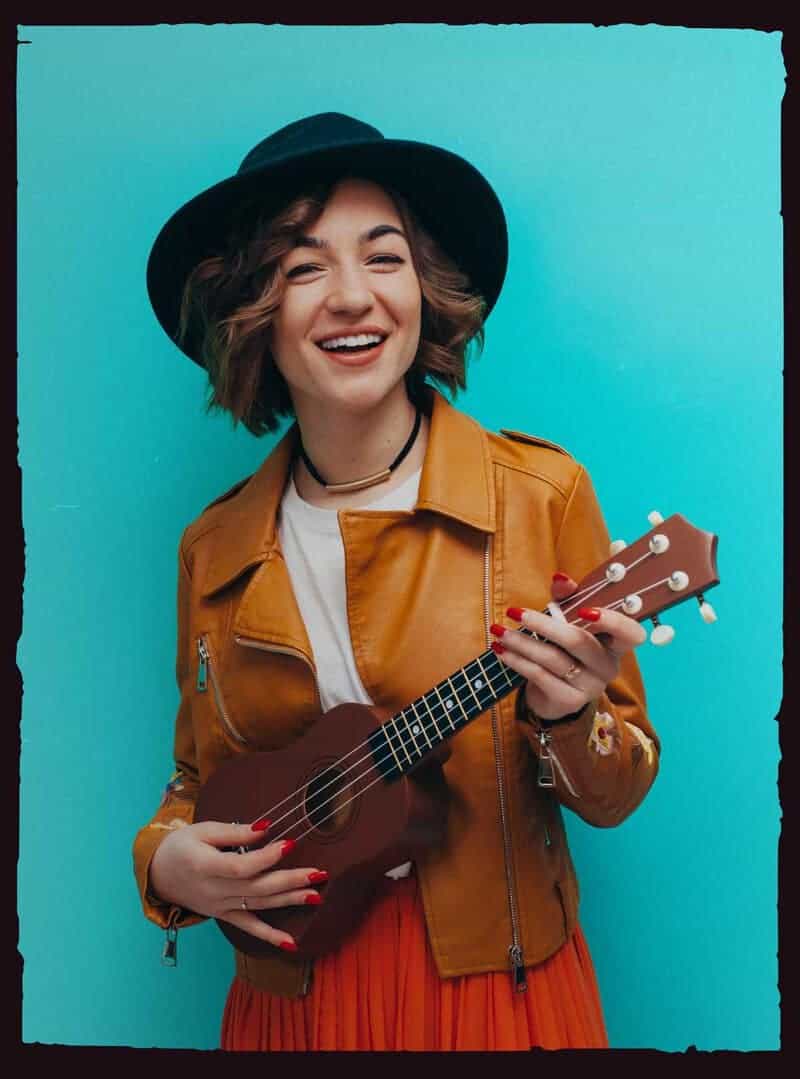 Young woman holding a ukulele guitar.