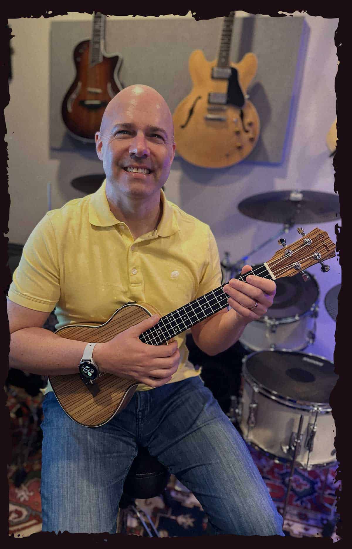 Barrett Simms smiling at a microphone on stage with an electric guitar.